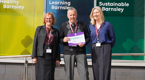 3 People Stood Holding A Certificate