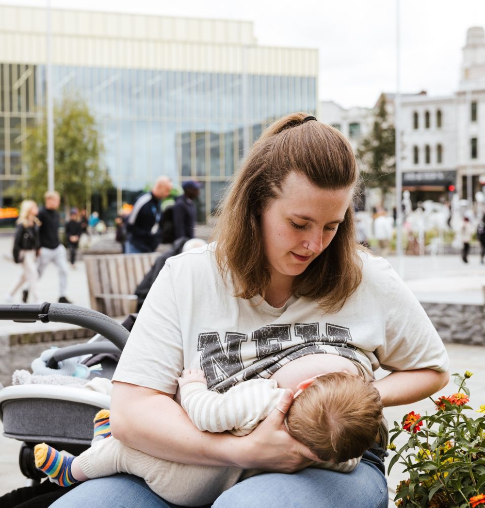 Woman breastfeeding her child in the glassworks square